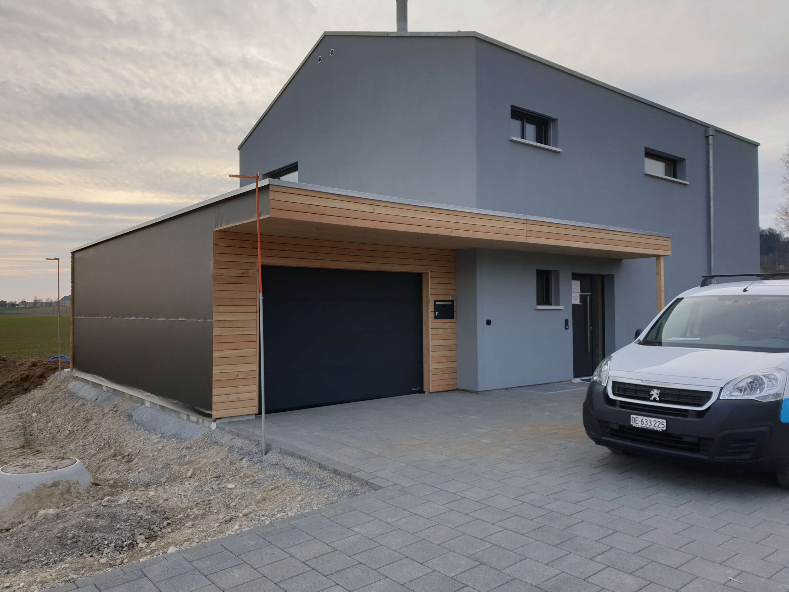 Moderner Holzanbau mit Carport
